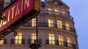 Un edificio con un cartello ben visibile con la scritta "ULITAIN" e diversi balconi con ringhiere decorate.
