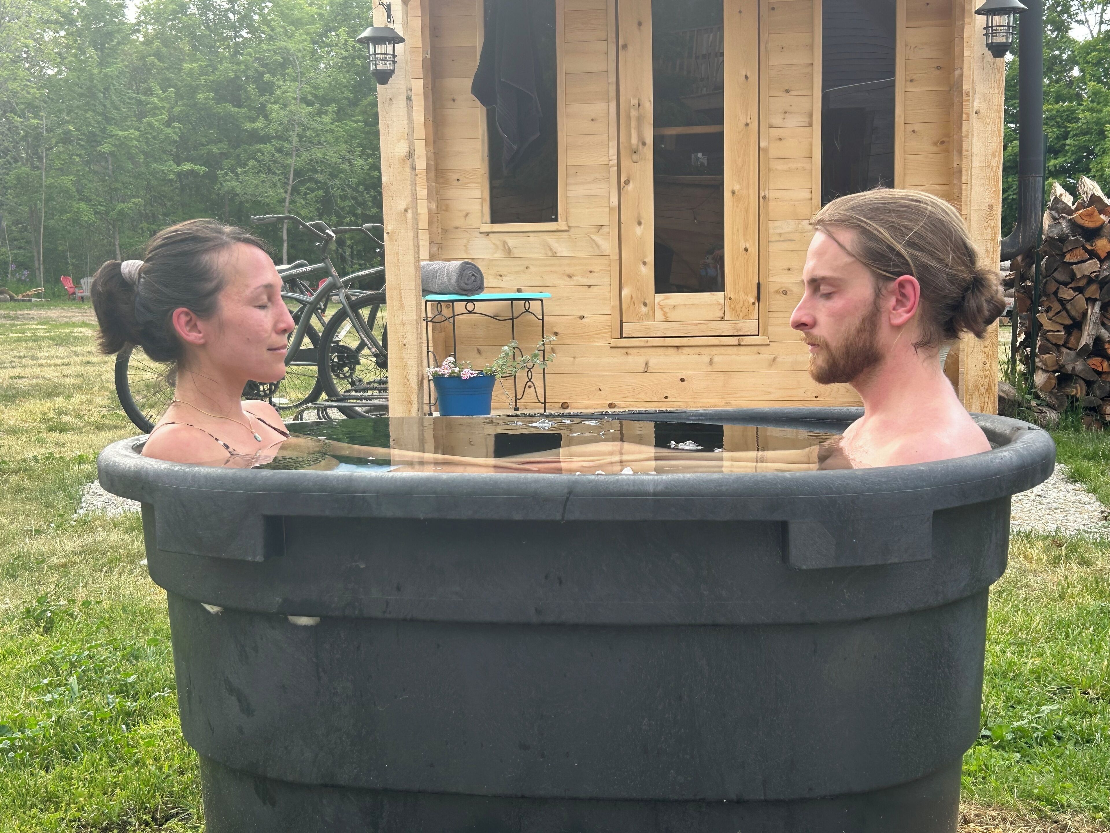 A wooden cabin with a hot tub in front.