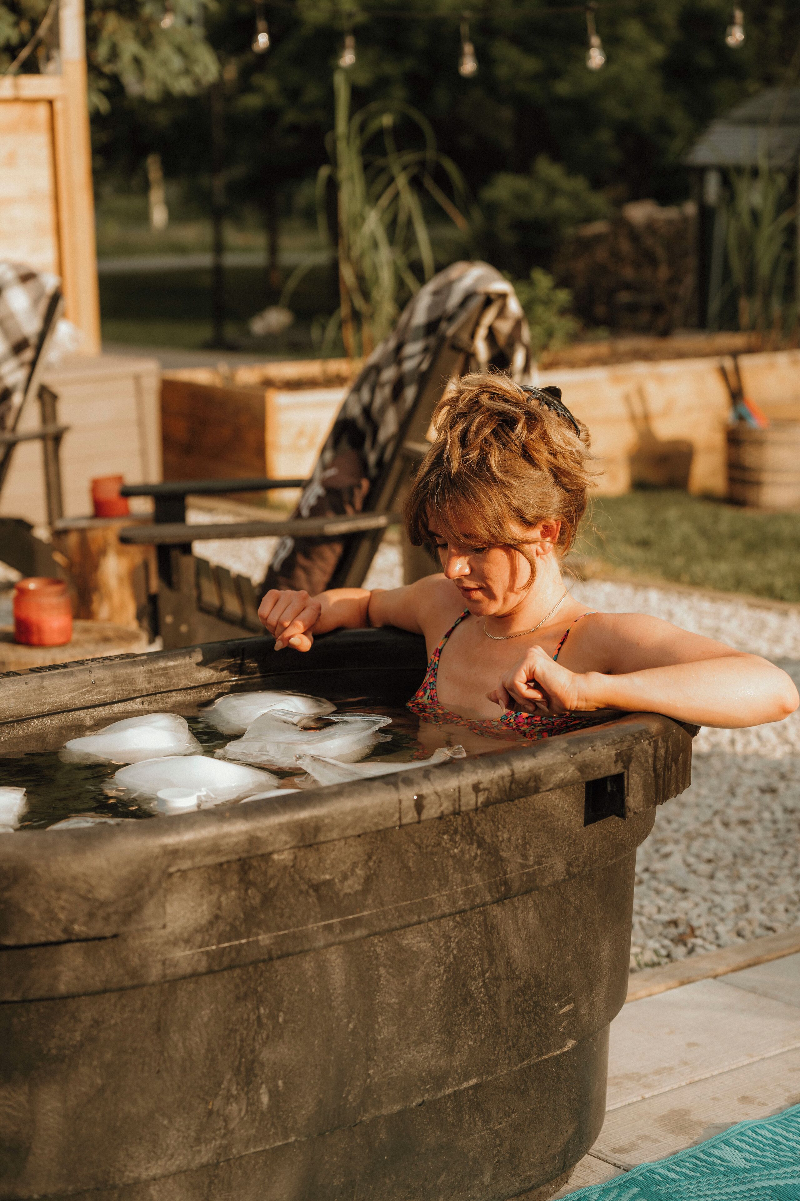 A person relaxing in a hot tub outdoors.