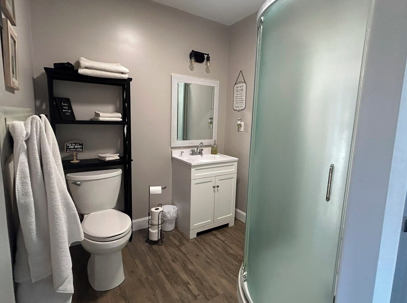 Un baño con inodoro, lavamanos y zona de ducha.