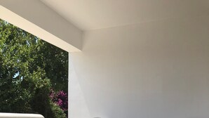 A patio with two white chairs with floral upholstery, a small table, and a bench. - Apartment 'Cozy  For Rent In Kythera' with Shared Terrace, Wi-Fi and Air Conditioning (Κύθηρα)