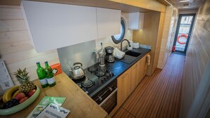 Una cocina pequeña con estufa, lavamanos y armarios de madera.