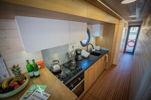 A compact kitchen with a stove, sink, and wooden cabinets.