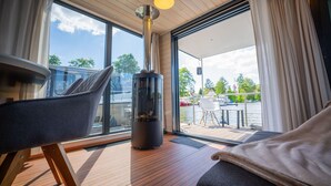 Une chambre moderne dotée d’une grande fenêtre, d’une cheminée et offrant une vue sur l’eau.