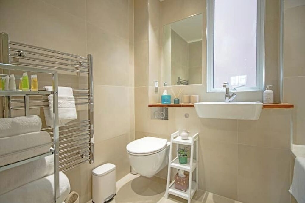 Ein modernes Badezimmer mit Toilette, Waschbecken und Handtuchhalter.