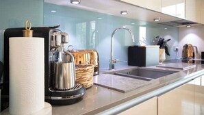 Eine moderne Küche mit Kaffeemaschine, Wasserkocher und einem Brotkorb.
