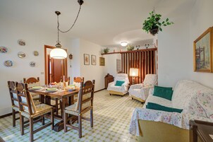 Un'area pranzo con un tavolo e sedie in legno, un lampadario e un pavimento decorato.