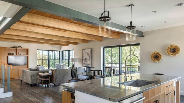 A modern kitchen with a large island, wooden beams, and large windows. - Stay at Old Garden Beach (Rockport)