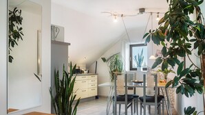 Cocina moderna con comedor, que incluye un espejo grande, plantas en macetas y una mesa con sillas.