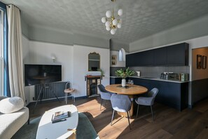 A modern living room with a fireplace, dining area, and kitchen. - Luxury 2.5 Bedroom Flat in Southsea (Portsmouth)
