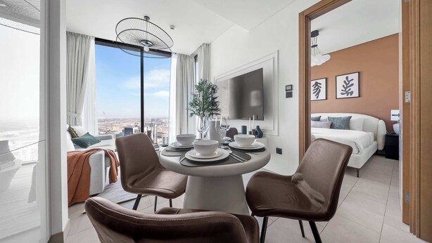 A modern hotel room with a dining area, a bed, and a television. - StayShort - Contemporary 1BR Meydan Sleeps 4 (Meydan)