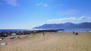 A beach with people, umbrellas, and a rocky shoreline. - Artist Lights in Luxury Apartment in the Center with A/C, WiFi, Outdoor Space (Salerno)