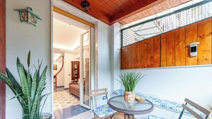 A patio with a round table, chairs, and potted plants. - Artist Lights in Luxury Apartment in the Center with A/C, WiFi, Outdoor Space (Salerno)