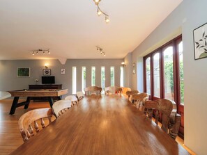 A spacious room with a long wooden table, several chairs, a pool table, and large windows. - Lady Of Lourdes (Ross-on-Wye)