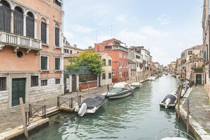 A canal in a historic European town with narrow streets and traditional buildings. - A Colorful Venetian Apartment Where You Can Relax (Venecia)
