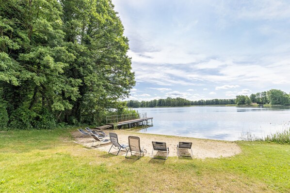 Un cadre idyllique au bord du lac, avec un quai, des chaises longues et une pelouse.