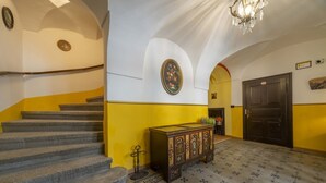 A staircase leading to a landing with a wooden cabinet and a chandelier. - GuestHost - A welcoming apartment of approximately 50 square meters, perfect for five people, located on the first floor of a historic building built in 1864 and renovated in 2025 while maintaining its historic atmosphere (NO elevator).The property is lo (Tarvisio)