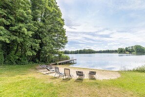 A lakeside area with a dock, lounge chairs, and a grassy area. - Holiday Apartment 'Wiese' with Lake View, Shared Terrace and Wi-Fi (Friedrichswalde)