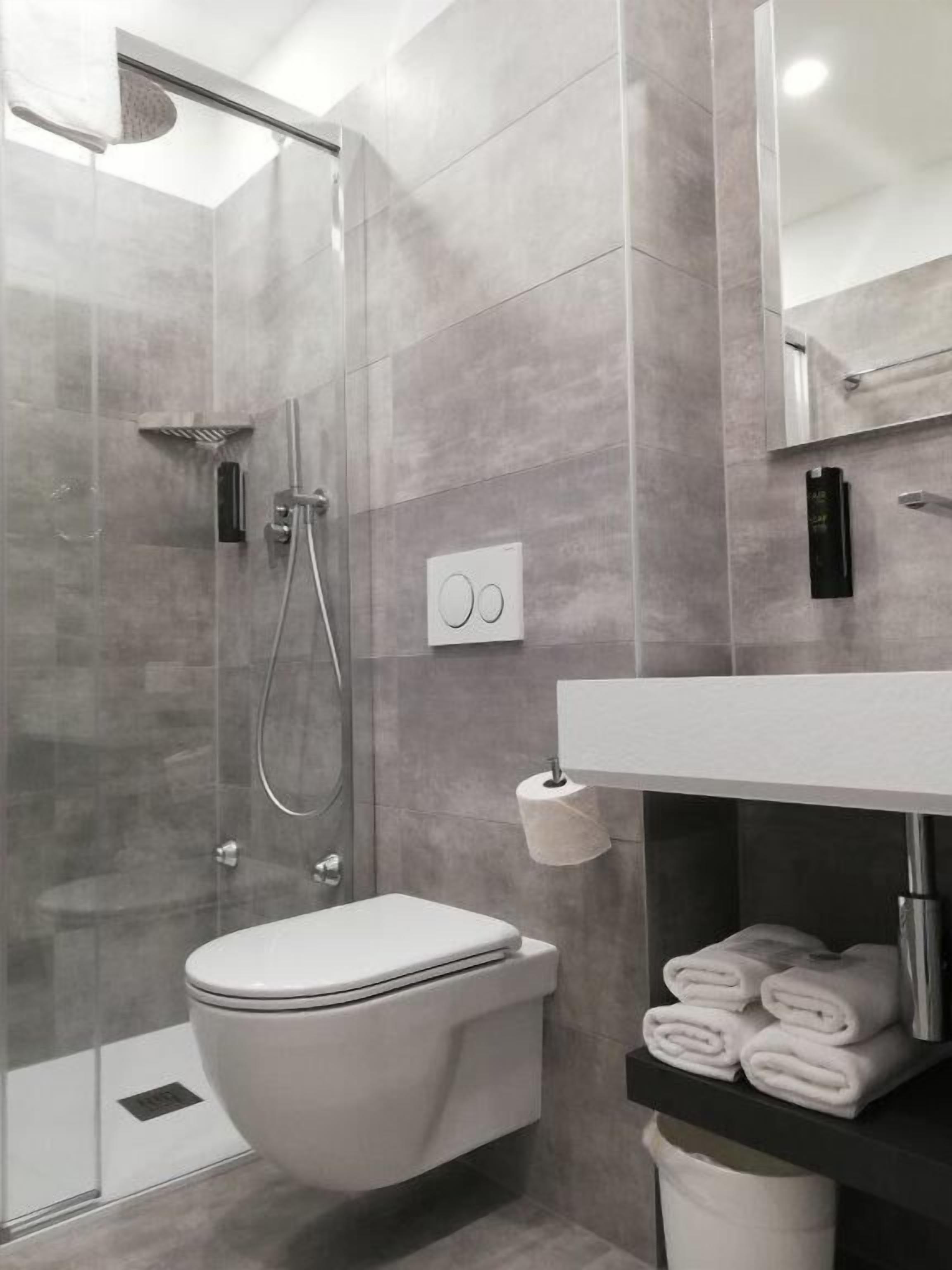 Un baño moderno con ducha, inodoro y toallero.