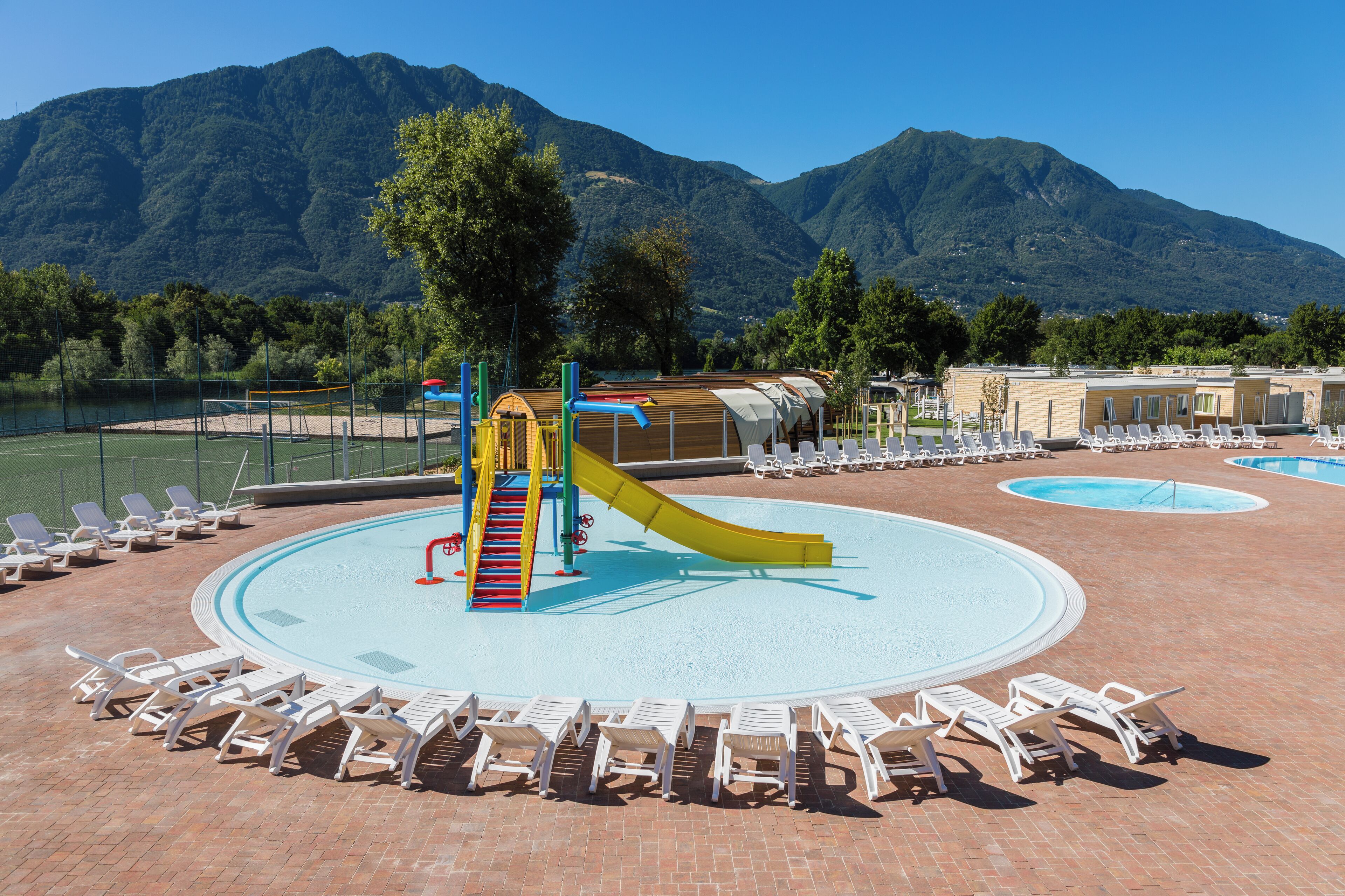 Una piscina al aire libre de temporada, sombrillas, tumbonas