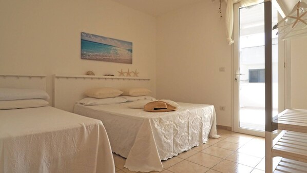 Un dormitorio con dos camas, un cuadro de una playa y una decoración de estrella de mar en la pared.