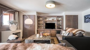 A living room with a sofa, a coffee table, a TV, and a lamp.