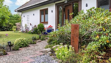 Et hvidt hus med en havegang, der fører til indgangen.