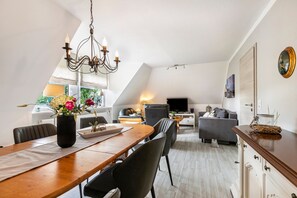 Un appartement moderne de style « loft » comprenant un coin repas, un salon et une cuisine.