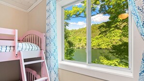 Una cama litera con vistas a un lago y un bosque.