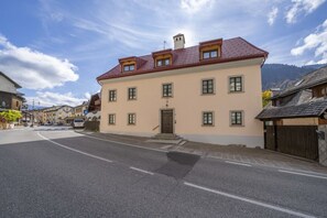 Ein Gebäude mit rotem Dach, zahlreichen Fenstern und einer Tür.