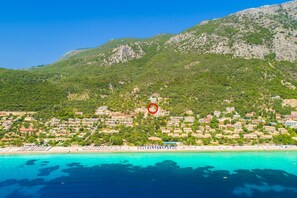 Eine Küstenstadt mit Strand, Gebäuden und einer Bergkulisse.