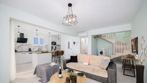 Un salon moderne avec un canapé, une table basse et un coin repas.