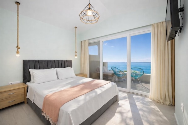A bedroom with a bed, bedside tables, a large window with a view of the sea, and a ceiling light fixture. - Villa Leo - Two Bedroom Villa, Sleeps 4 (Mparmpati)