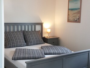 Un letto con testiera, due comodini e una lampada da notte.