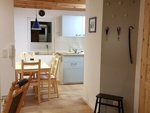 A compact kitchen with a sink, cabinets, and a blue pendant light.