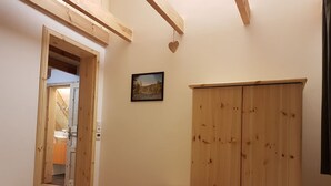 A bedroom with wooden furniture, a small stool, a bed, and a wardrobe. - Apartment "Olsberg Blick Whg.A" with Mountain View, Garden & Wi-Fi (Olsberg)