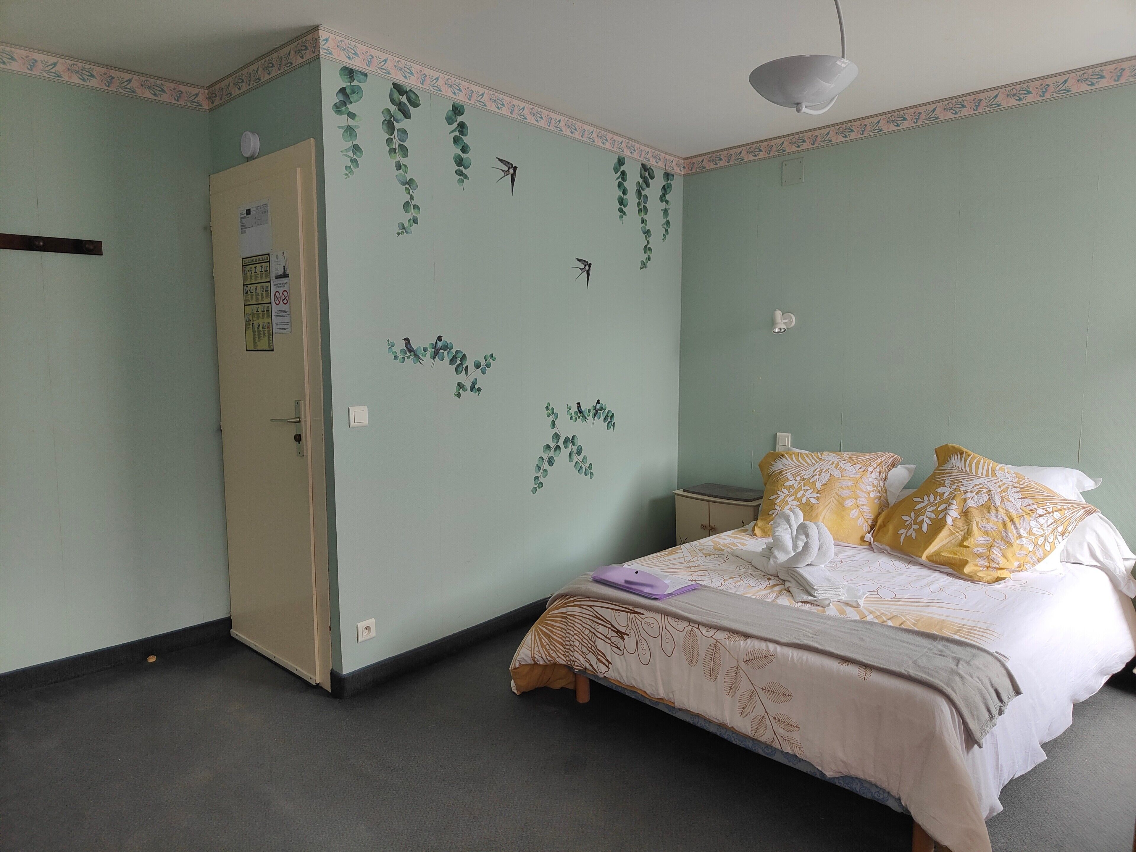 Une chambre comprenant un lit, une table de chevet, une armoire et des éléments de décoration murale.