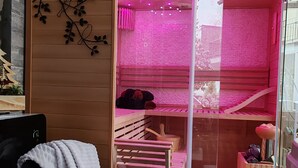 Une pièce avec un lit superposé en bois, une petite table et une cloison en verre.