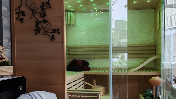 A modern room with a sliding glass door, a wooden bench, a small wooden table, and a wall-mounted plant.