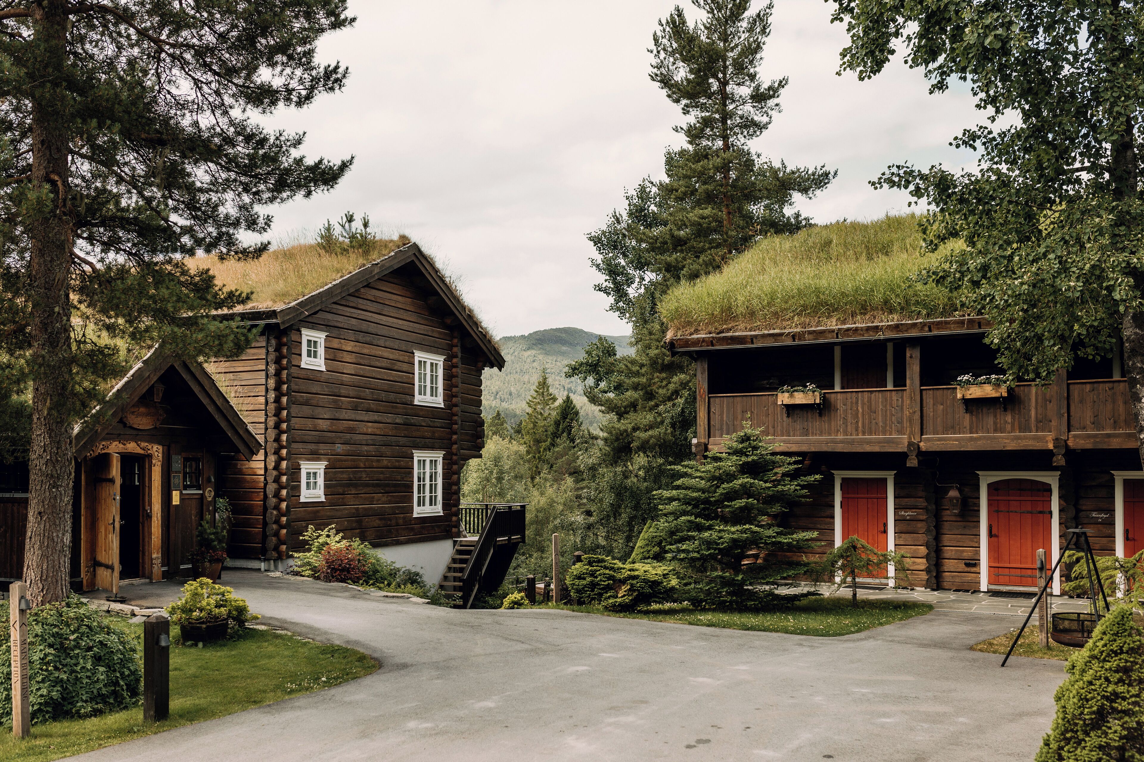 A rustic log cabin with a wooden exterior, a front porch, and a staircase leading to the entrance.
