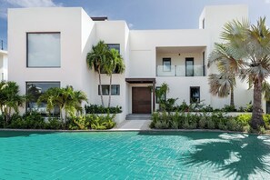 Ein modernes, zweistöckiges Gebäude mit einem Pool davor.