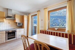 Eine Küche mit Holzschränken, einer Mikrowelle und einem Backofen.