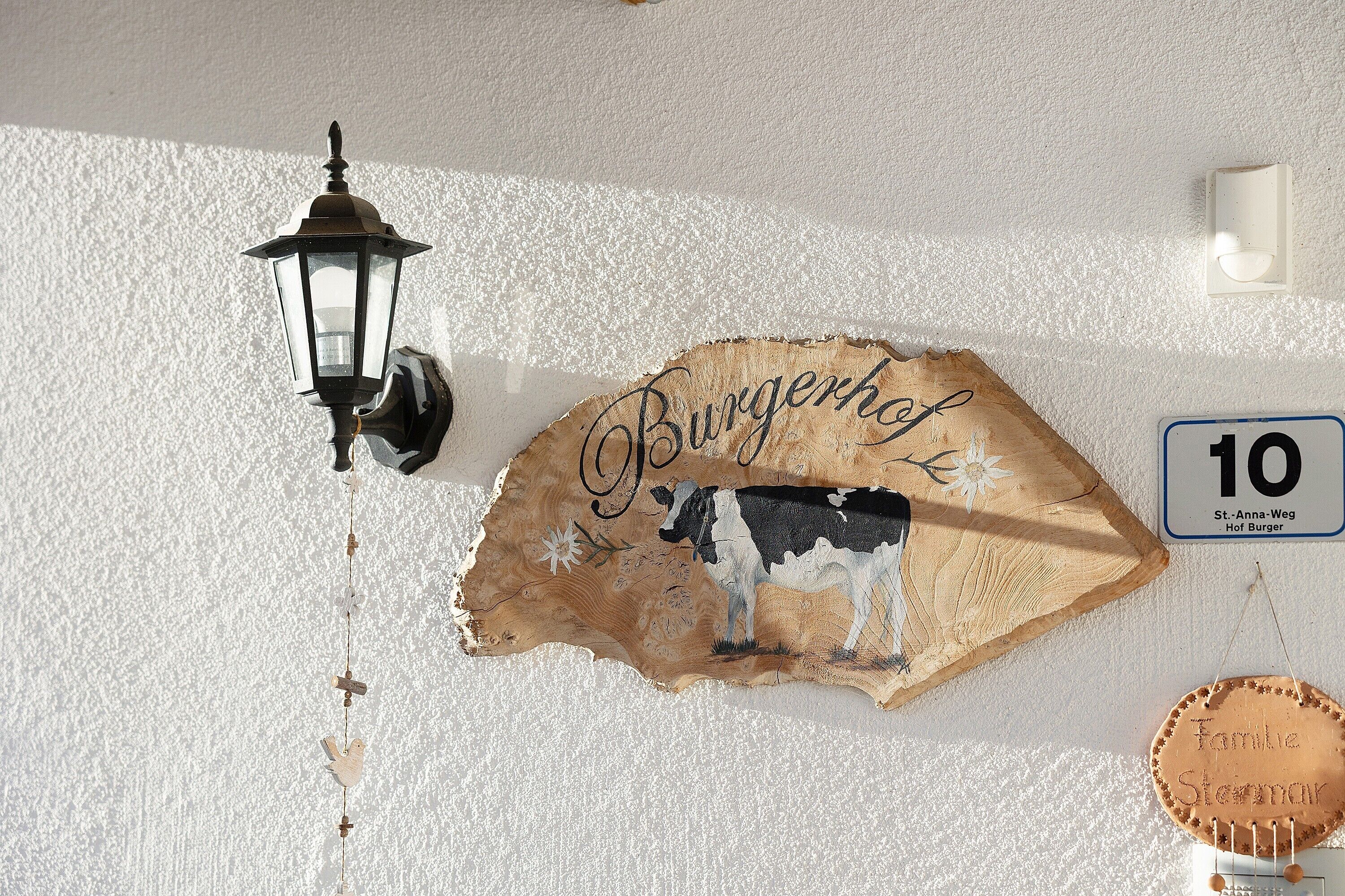 Segnaletica a parete con illustrazione di una mucca e la scritta 'Burgershop' su una parete strutturata.