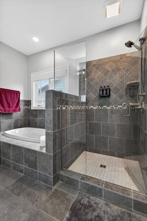 A modern bathroom with a walk-in shower, a bathtub, and a glass-enclosed shower area. - Bella Shores - Stunning Sunsets & Sandy Shoreline (Coldwater)