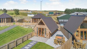 A series of wooden cabins with sloped roofs, outdoor seating, and a gravel patio. - 1 bedroom accommodation in Ripponden (Ripponden)