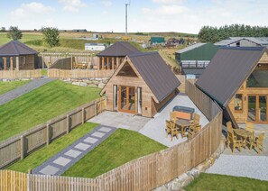 A series of wooden cabins with sloped roofs, outdoor seating, and a gravel patio. - 1 bedroom accommodation in Ripponden (Ripponden)