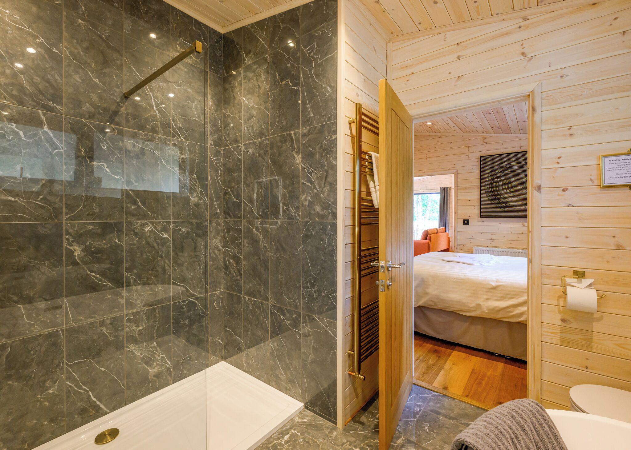 Een badkamer met douche, toilet en wastafel.