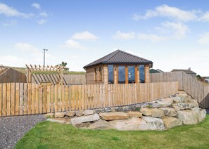 A wooden cabin with a sloped roof, large windows, and a wooden fence surrounding the property. - 1 bedroom accommodation in Ripponden (Ripponden)