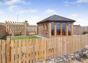 A wooden cabin with a fenced backyard, a pergola, and a hot tub. - 1 bedroom accommodation in Ripponden (Ripponden)