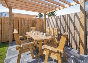 A wooden pergola with a table and chairs, a wooden fence, and a tree in the background. - 1 bedroom accommodation in Ripponden (Ripponden)